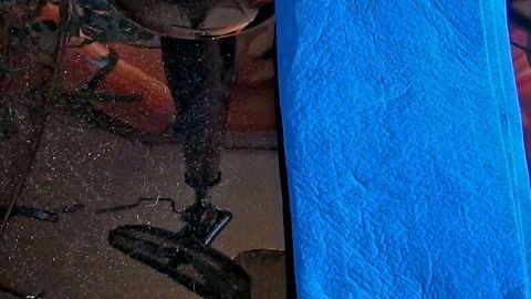 Nachdem ich die Möbel entstaubt habe, reibe ich sie mit Glycerin aus der Apotheke ein. Erstens haben sie danach einen leichten Glanz und sie bleiben länger staubfrei. Auf einem staubfreien schwarzen Möbelstück liegt ein blauer Lappen, bereit zum Wischen. Die Umgebung ist eher dunkel gehalten.