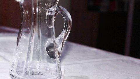 Eine gläserne Karaffe steht auf einem Tisch und wartet darauf, mit Backpulver und Oxi zur Reinigung von Weinrand genutzt zu werden.