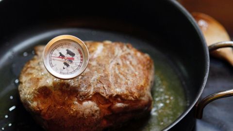 So kann man die Temperatur ermitteln, damit der Braten zartrosa wird: Dieser Tipp stammt von J.B. Kerners Kochexperten. Ein saftiger Braten liegt in einer Pfanne, während ein Thermometer die Temperatur ermittelt, um ihn zartrosa zu garen.