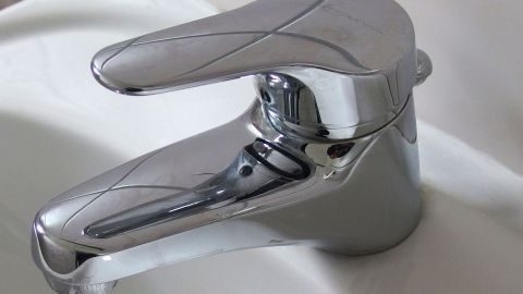 Ein glänzender Wasserhahn steht bereit, um Wasser zu liefern, während sich Kalkablagerungen auf der Oberfläche zeigen.