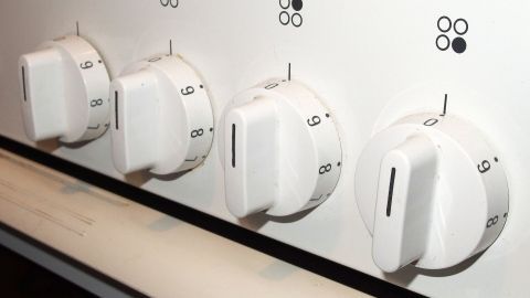 Elektroherd-Schalter lassen sich nur schwer reinigen? Mit diesem Tipp klappt es ziemlich gut. Weiße Drehknöpfe eines Elektroherds werden sichtbar mit einem Backofenspray gereinigt, um Schmutz zu entfernen.