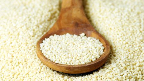 Wusstest du, dass du Couscous als Hackfleischersatz verwenden kannst? Eine tolle vegetarische und günstige Variante! Couscous liegt auf einem Holzlöffel, umgeben von mehr Couscous, und verdeutlicht die Verwendung als Hackfleisch-Ersatz.