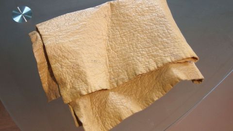 Mithilfe von Schmierseife hartes Fensterleder wieder weich bekommen. Ein gelbes Fensterleder liegt gefaltet auf einer glatten Oberfläche, bereit, mit Schmierseife behandelt zu werden.