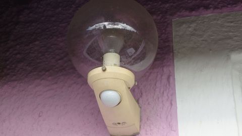 Mit einer Außenlampe mit Bewegungsmelder kann man Strom sparen. Ein Bewegungsmelder ist an einer Wand montiert und erkennt Bewegung, um eine Lampe zu aktivieren.