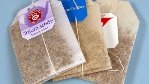 Für ein schönes Bad muss es nicht immer ein Badesalz sein - man kann Teebeutel verwenden. Teebeutel liegen auf einem hellblauen Tisch. Sie sind bereit, für ein entspannendes und günstiges Bad verwendet zu werden.