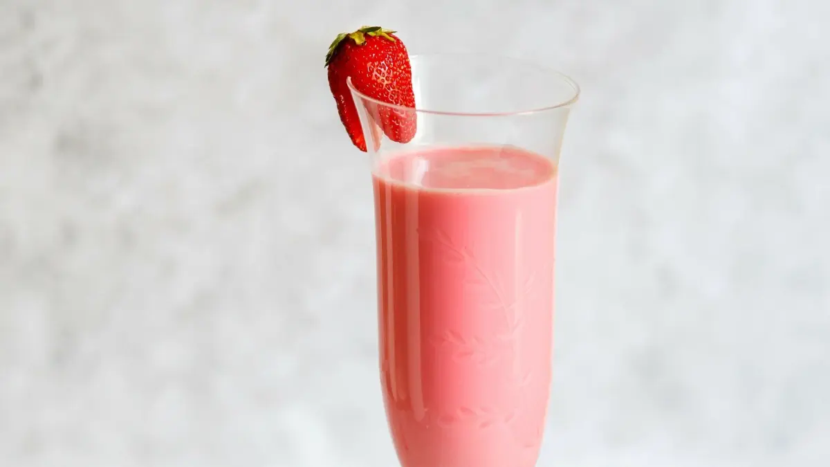 Ein Erdbeer-Schlamm-Bowle in einem eleganten Glas, umgeben von frischen Erdbeeren auf einem Tellerrand.