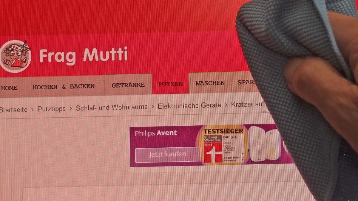 Ein Hand wischte mit einem Tuch &uuml;ber einen Computerbildschirm, auf dem "Kratzer auf Bildschirm" steht.