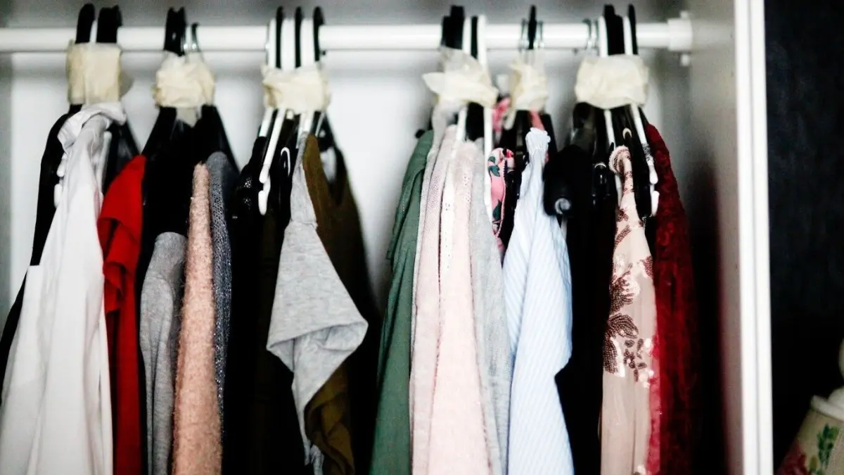 H&auml;ngende Kleidung in einem Schrank wird zum Verpacken f&uuml;r den Umzug vorbereitet, um organisiert zu bleiben.
