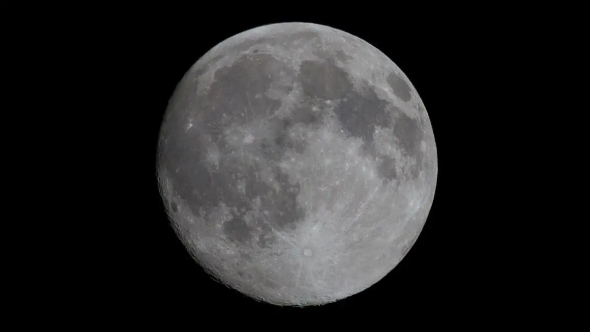 Der Mond leuchtet hell am Nachthimmel und zeigt detaillierte Kraterstrukturen, umgeben von einem tiefschwarzen Hintergrund.