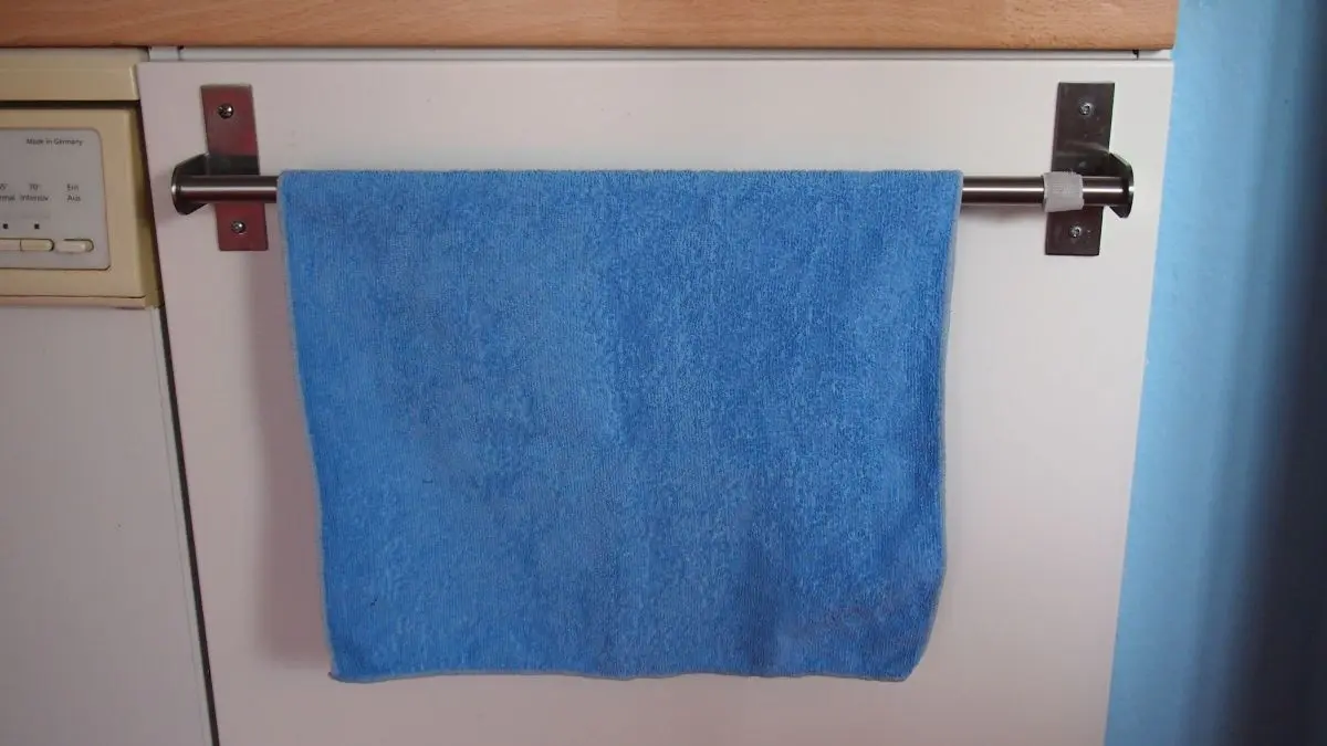 Ein blaues Handtuch h&auml;ngt stabil an einer Handtuchstange in einem Badezimmer, ohne herunterzurutschen.