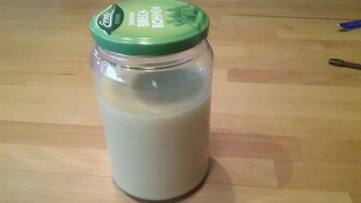 Ein Glas mit Zitronenpaste steht auf einem Holzbrett, bereit zur Verwendung f&uuml;r die Reinigung von Edelstahl.