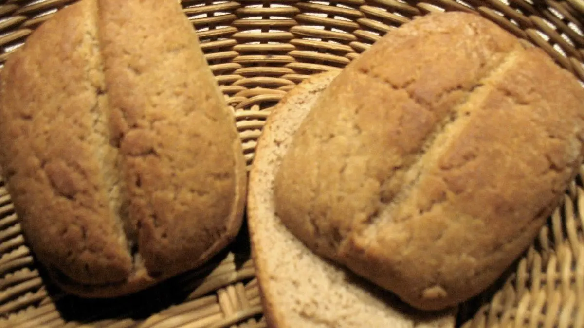 Schnelle Br&ouml;tchen aus Roggenmehl liegen frisch in einem geflochtenen Korb, umgeben von einer warmen, einladenden Atmosph&auml;re.