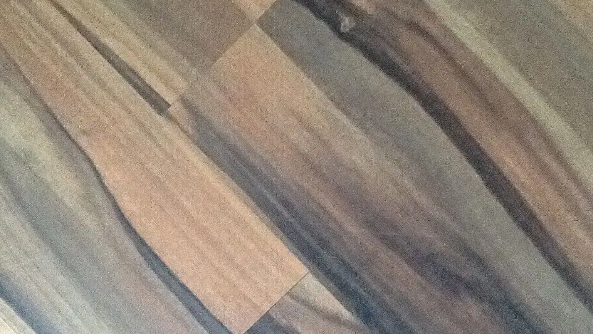 Dunkles Laminat zeigt eine strukturierte Oberfl&auml;che mit verschiedenen braunen und grauen Holzmaserungen in einem eleganten Design.