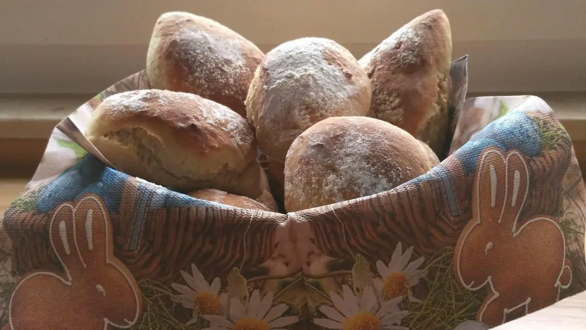 In einer dekorativen Schale liegen frisch gebackene Joghurtbr&ouml;tchen, umgeben von einem hellen K&uuml;chenambiente.