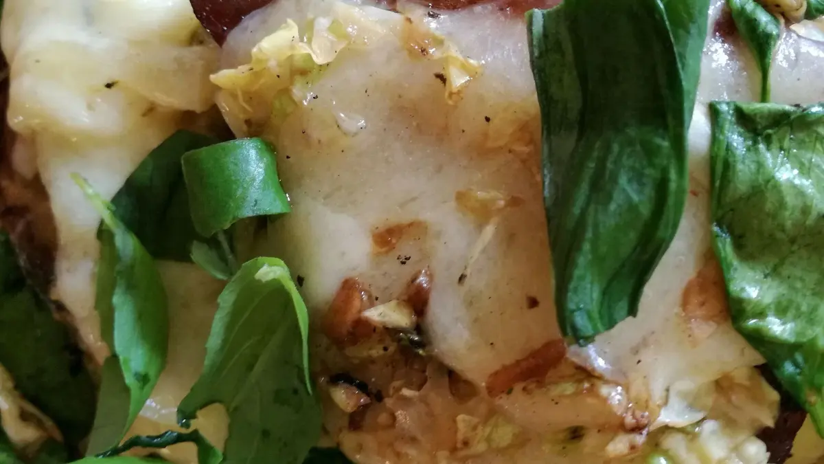 Saftiges Thunfisch-Filetsteak liegt auf frischem Gem&uuml;se, &uuml;berbacken mit schmelzendem Bergk&auml;se in einem bunten Mix.