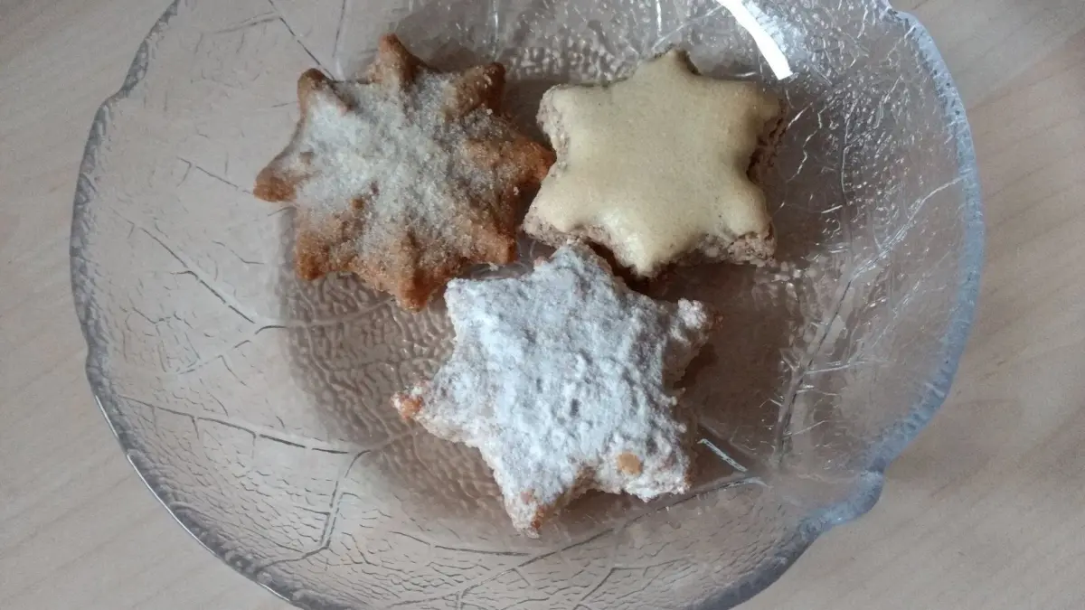 Eine klare Glasschale enth&auml;lt drei gefrorene Kekse, die in verschiedenen Farben leicht glitzern.