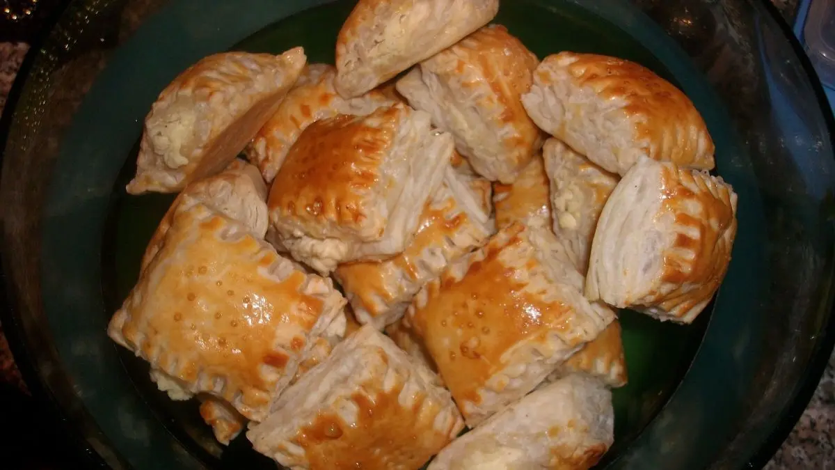 Bl&auml;tterteig-Fingerfood liegt appetitlich in einer Sch&uuml;ssel, frisch gebacken und goldbraun, bereit zum Genie&szlig;en.