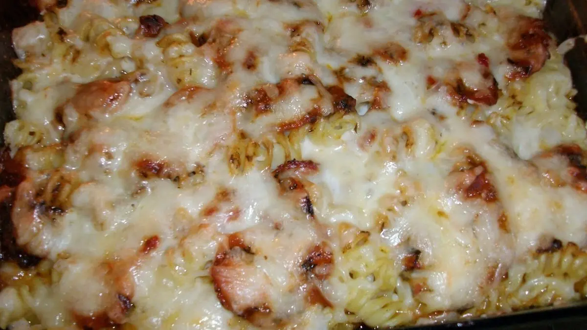 Ein &uuml;berbackener Gem&uuml;seauflauf aus Dinkelspirelli mit geschmolzenem K&auml;se, serviert in einer Auflaufform.