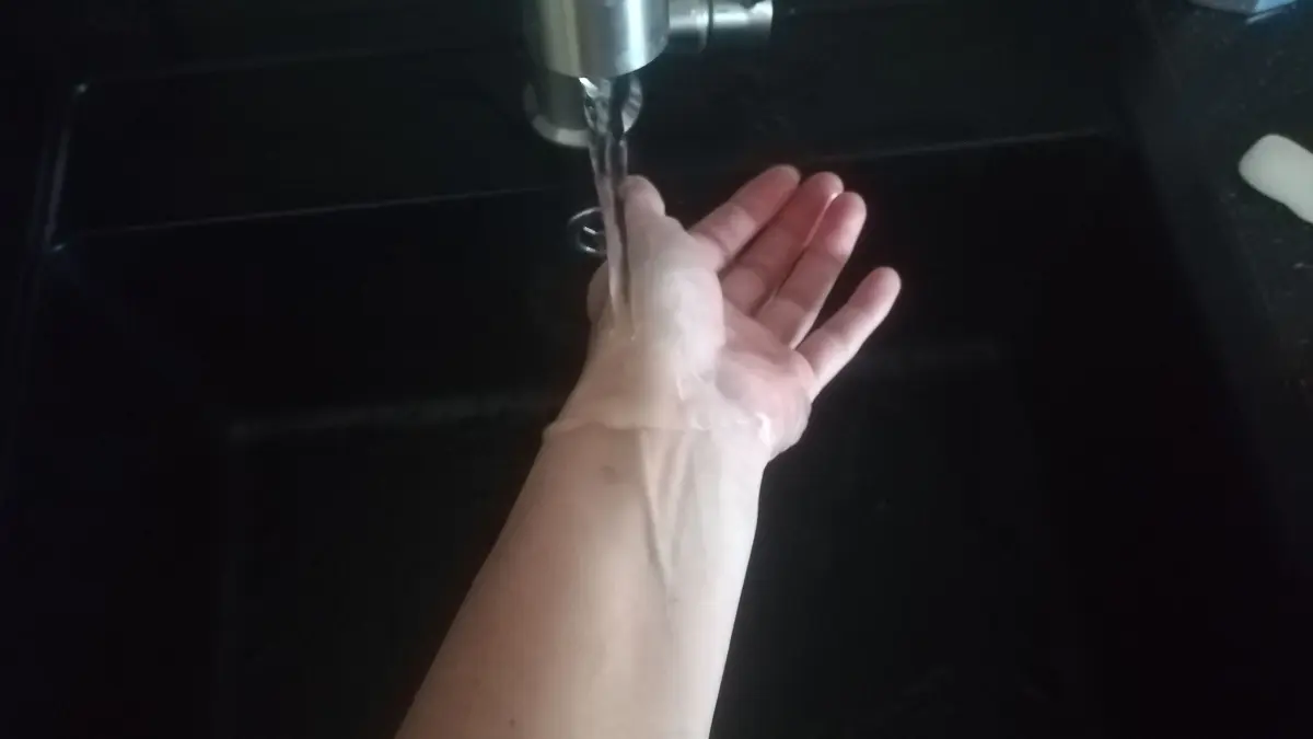 Ein Arm h&auml;lt sich unter einem Wasserhahn, w&auml;hrend frisches Wasser flie&szlig;t &ndash; ein erfrischender Start in den Tag.
