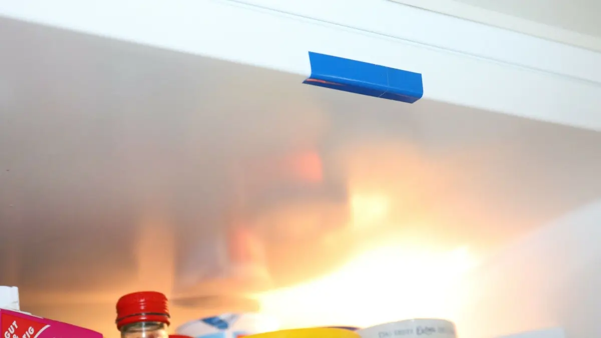 Der K&uuml;hlschrank zeigt ein blauer Klebestreifen, der die T&uuml;r abdichtet und so Energieverlust im Innenraum verhindert.