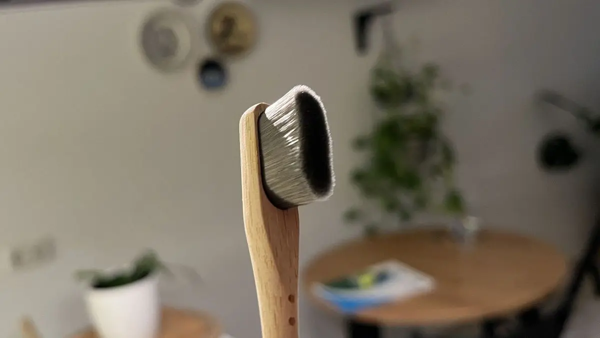 Eine Nano-Zahnb&uuml;rste steht im Vordergrund, w&auml;hrend sie in einer modernen K&uuml;che auf einem Tisch abgestellt ist.