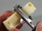 Käse mit Sparschäler in Scheiben schneiden