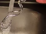 Teigreste an Küchenutensilien & Händen mit kaltem Wasser abwaschen