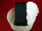 Nasses Handy retten mit Platikbeutel und Katzenstreu