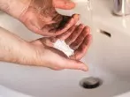 Ölverschmierte Hände mit Waschpulver reinigen