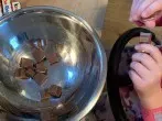 10 von den 13 Schokoriegel werden in kleine St&uuml;cke gebrochen.    Schokost&uuml;cke zum Teig geben und verr&uuml;hren.