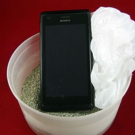 Nasses Handy retten mit Platikbeutel und Katzenstreu