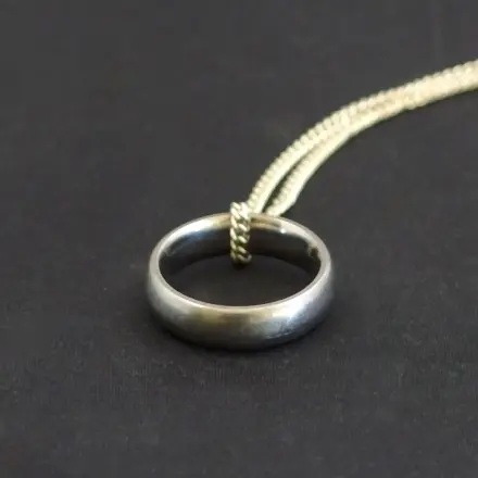 Zu eng gewordene Ringe als Anhänger an einer Kette tragen