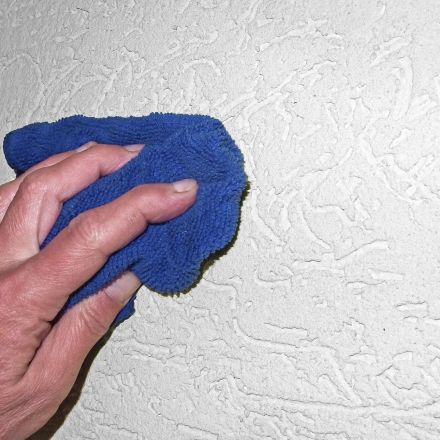 Mückenflecken an der Wand mit Microfasertuch abwischen