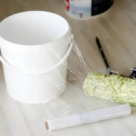 Arbeit sparen: Farbeimer für Wandfarbe mit Folie auslegen