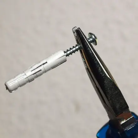 Dübel entfernen mit Schraube und Zange