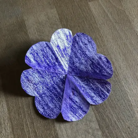 Faltet man das Papierchen auf, ist eine süße Blume mit acht Blütenblättern entstanden.