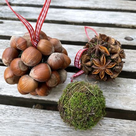 Weihnachtskugeln aus Moos und Haselnüssen