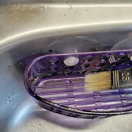 Schwammhalter in Spüle mit Pinsel reinigen