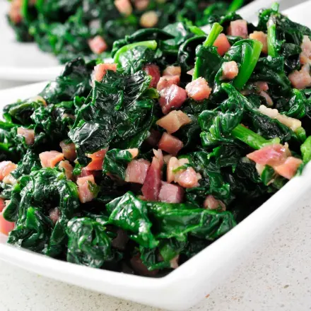 Rahmspinat mit geräucherten Schinkenwürfeln und Zwiebeln