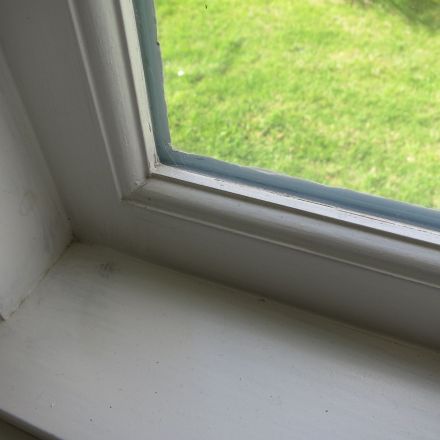 Weiße Holzfenster mit weißer Silikonfuge