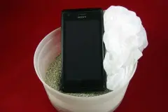 Nasses Handy retten mit Platikbeutel und Katzenstreu