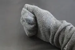 Eingecremte H&auml;nde im Bett: Socken-Handschuhe