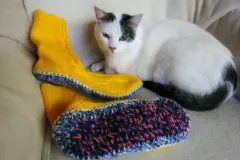 Gestrickte Socken mit dicken Sohlen als Hausschuhe