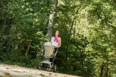 Kind im Kinderwagen mit Blickkontakt zu den Eltern