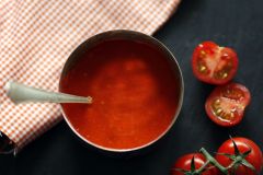 Die Tomaten, der L&ouml;ffel und die Stoffserviette peppen das Foto der eher einfarbigen Tomatensuppe stark auf.